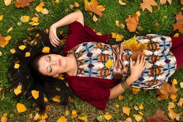 La mujer joven hermosa se relaja en un parque