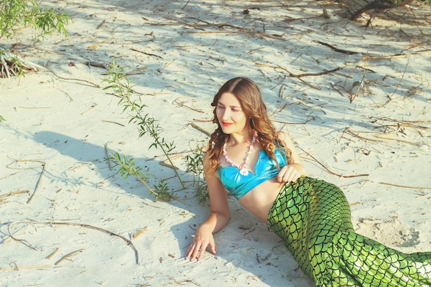 Mujer joven hermosa sirena de cerca en la costa del mar. Cosplay de sirena.