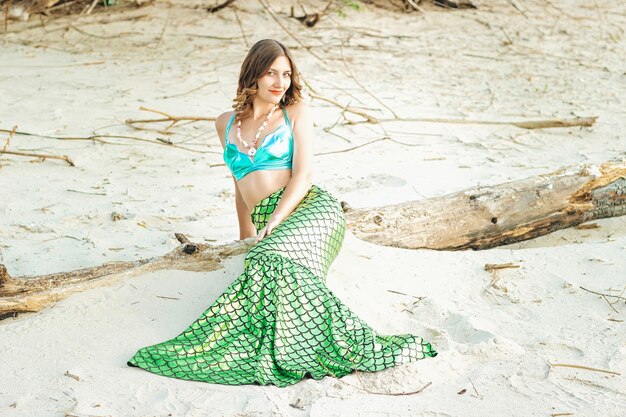 Mujer joven hermosa sirena de cerca de pie en la costa del mar. Cosplay de sirena.