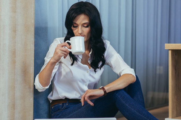 mujer joven hermosa tomando café