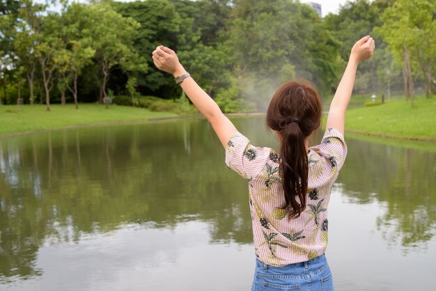 Mujer joven hermosa turista asiática relajante en el parque