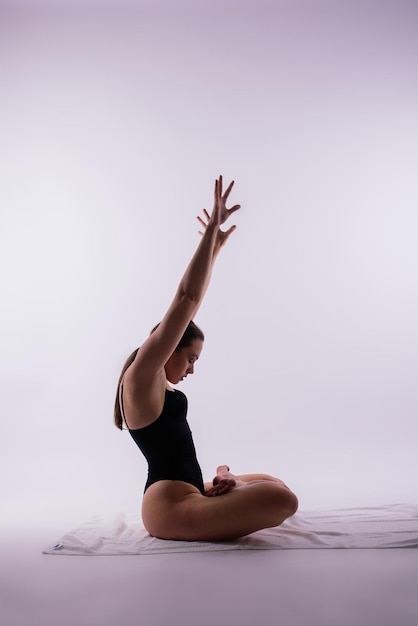 Mujer joven hermosa yoga posando sobre un fondo de estudio