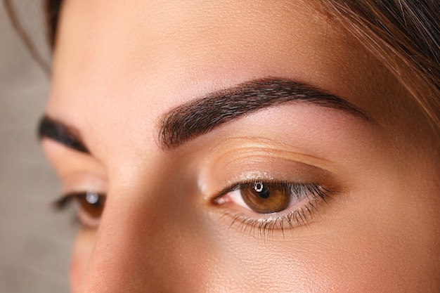 Mujer joven con hermosas cejas después de la corrección, primer plano