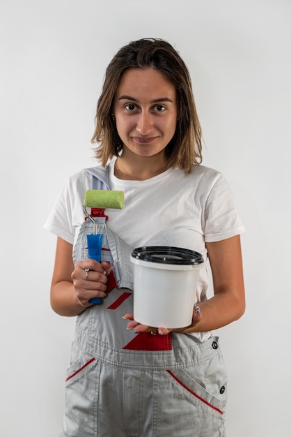 Mujer joven con herramientas de reparación en ropa especial aislado sobre fondo blanco reparación de casas de construcción