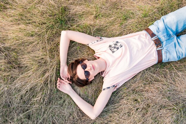 Mujer joven en la hierba tomando tiempo para apreciar la primavera