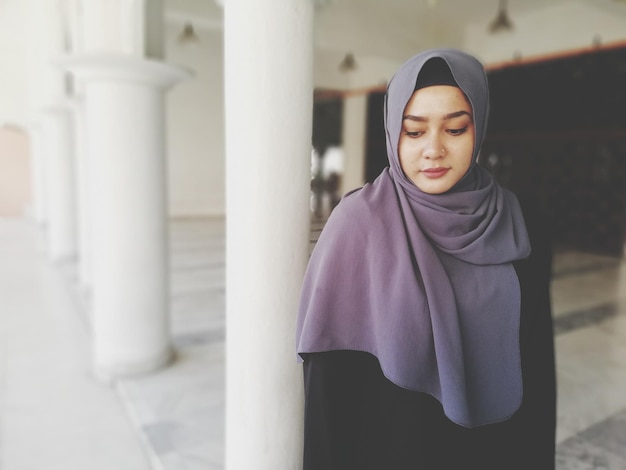 Mujer joven con hijab mirando hacia abajo