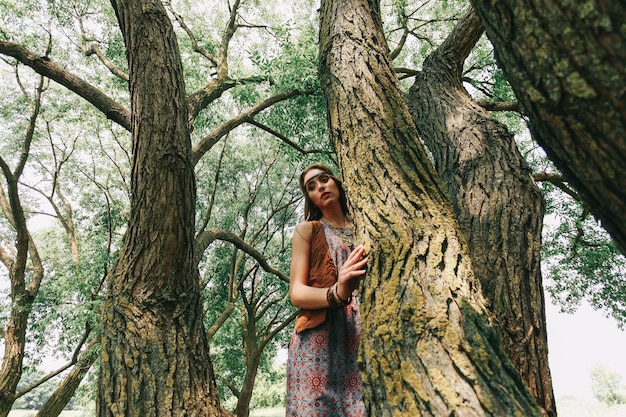 Mujer joven hippie en un paseo por el bosque