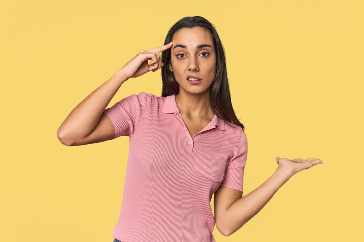 Foto mujer joven hispana sosteniendo y mostrando un producto en la mano