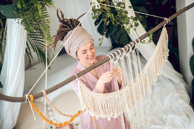 Foto mujer joven, en, un, homewear, trenzado, macramé