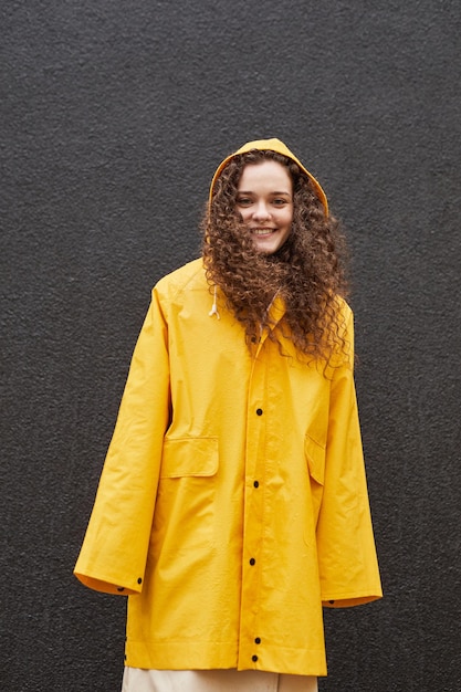 Mujer joven en impermeable amarillo