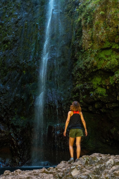 Una mujer joven en la impresionante cascada de la Levada do Caldeirao Verde Queimadas Madeira