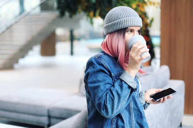 Mujer joven inconformista con cabello rosado y sombrero