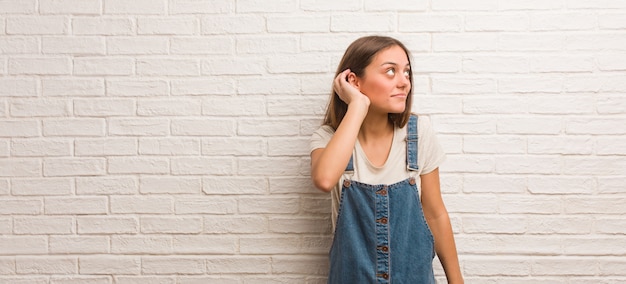 Mujer joven inconformista intenta escuchar un chisme