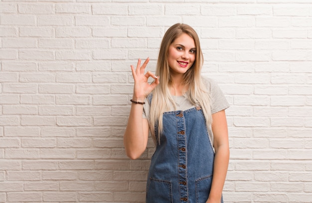 Mujer joven inconformista ruso alegre y confiado haciendo gesto bien