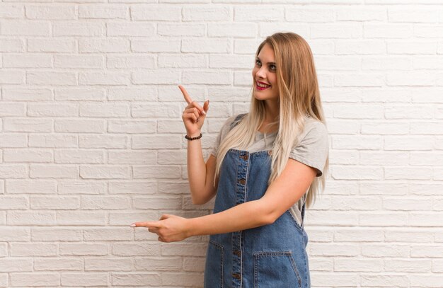 Mujer joven inconformista ruso apuntando hacia el lado con el dedo