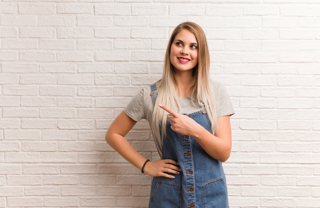 Mujer joven inconformista ruso sonriendo y apuntando hacia el lado