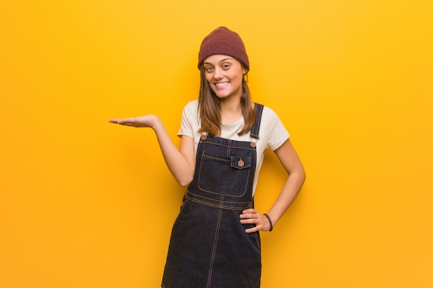 Mujer joven inconformista sosteniendo algo con la mano