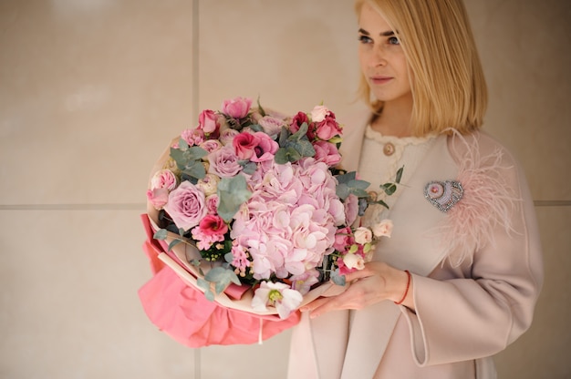 Mujer joven con increíble ramo de flores