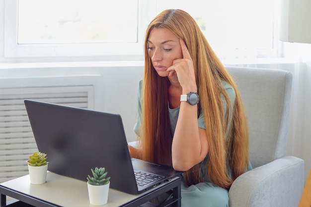 mujer joven independiente trabaja en casa para un aprendizaje en línea portátil