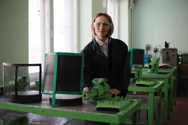 Mujer joven ingeniero trabajando en máquina herramienta