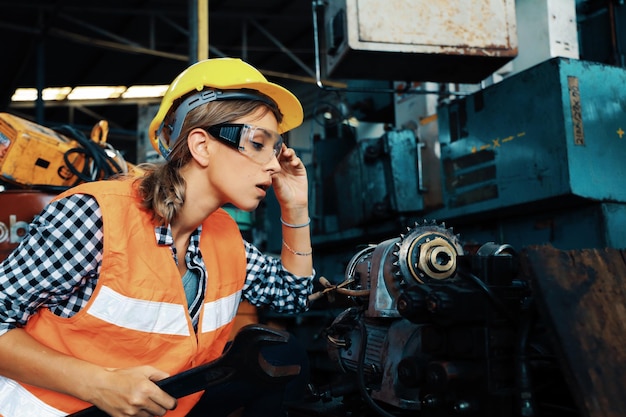 Mujer joven inteligente que trabaja en la fábrica de ingeniería