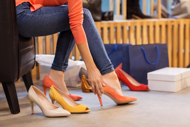 Foto mujer joven intentando zapatos de tacón alto en la tienda