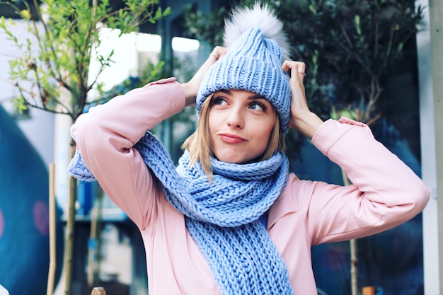 Foto mujer joven en el invierno con gorro de punto y bufanda