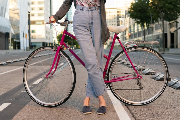 Mujer joven irreconocible con una bicicleta retro rosa