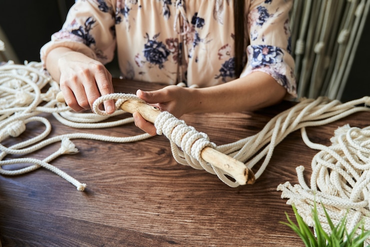 Foto mujer joven irreconocible haciendo una decoración de macramé en un espacio de trabajo