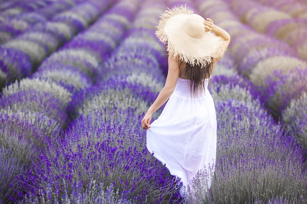 Mujer joven irreconocible de pie en el campo de lavanda. Señora en verano