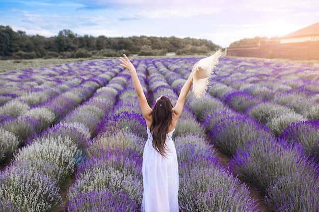 Mujer joven irreconocible de pie en el campo de lavanda. Señora en verano