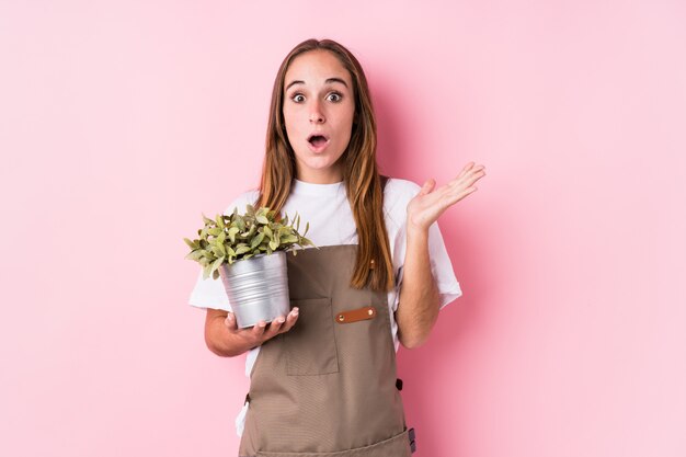 Mujer joven jardinero sorprendida y conmocionada