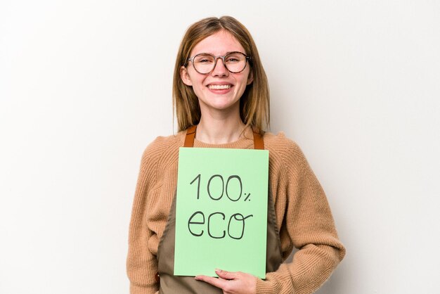 Mujer joven jardinero sosteniendo un cartel 100 eco aislado sobre fondo blanco feliz sonriente y alegre