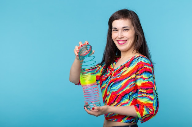 mujer joven, juego, con, un, furtivo, en, pared azul