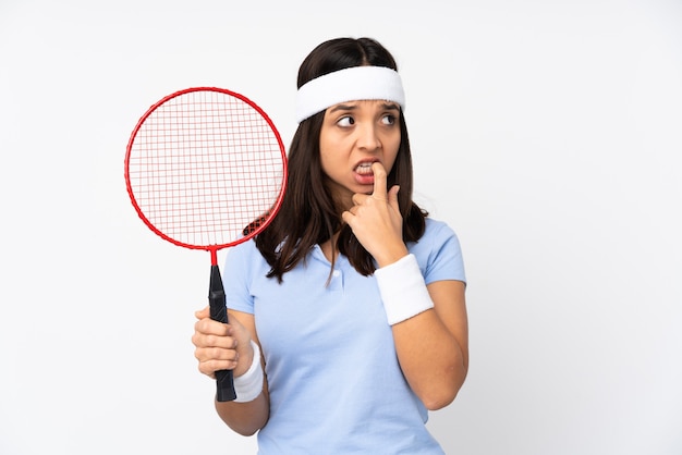 Mujer joven jugador de bádminton sobre fondo blanco aislado nervioso y asustado