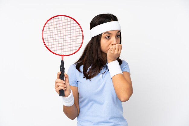 Mujer joven jugador de bádminton sobre fondo blanco aislado tener dudas