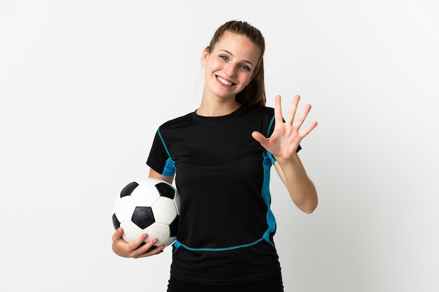 Mujer joven jugador de fútbol aislado en la pared blanca contando cinco con los dedos