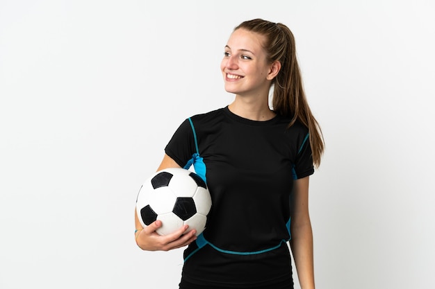 Mujer joven jugador de fútbol en blanco mirando hacia el lado y sonriendo