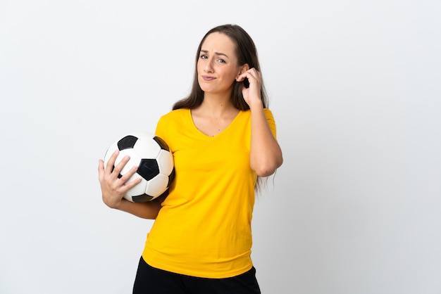 Mujer joven jugador de fútbol sobre pared blanca aislada que tiene dudas