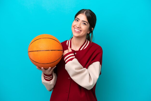 Mujer joven jugadora de baloncesto caucásica aislada de fondo azul celebrando una victoria