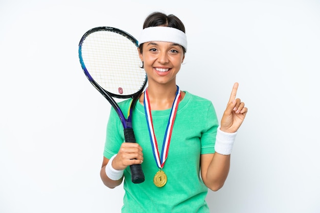 Mujer joven jugadora de tenis aislada de fondo blanco mostrando y levantando un dedo en señal de lo mejor