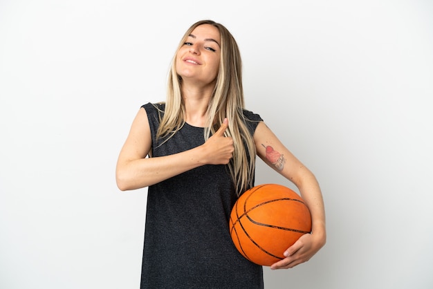 Mujer joven jugando baloncesto sobre pared blanca aislada dando un pulgar hacia arriba gesto