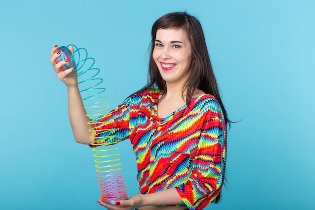 Mujer joven jugando con un furtivo en la pared azul