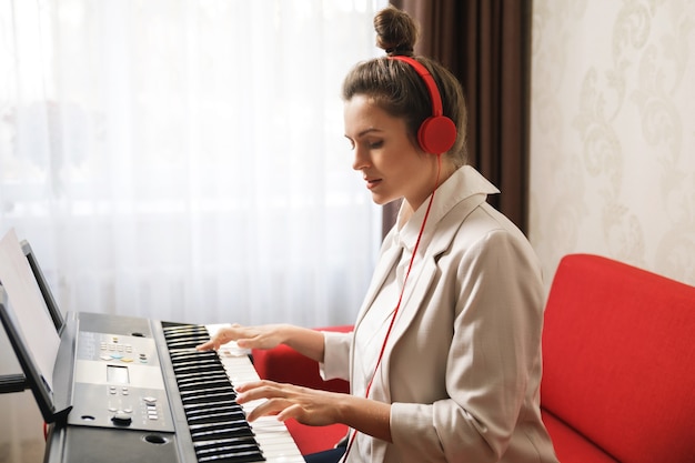 Mujer joven jugando sintetizador en casa