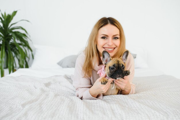 Mujer joven jugando con su perro en casa