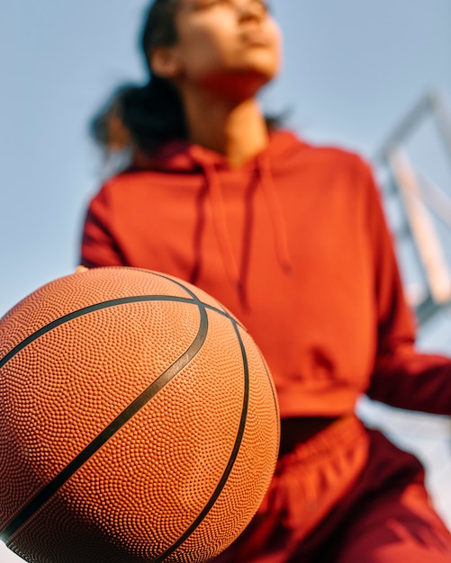 Mujer joven, jugar al básquetbol, aire libre