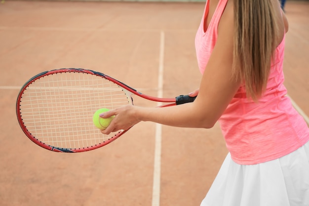 Mujer joven, jugar al tenis, en, cancha