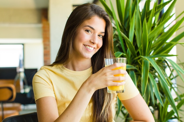 Foto mujer joven con jugo en casa