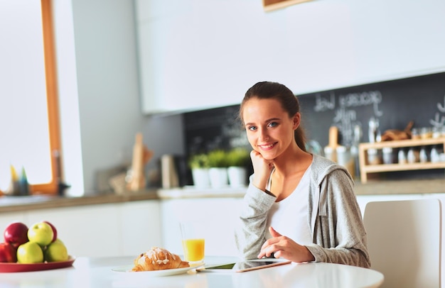 mujer joven, con, jugo de naranja, y, tableta, en, cocina