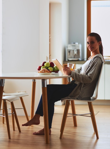 mujer joven, con, jugo de naranja, y, tableta, en, cocina